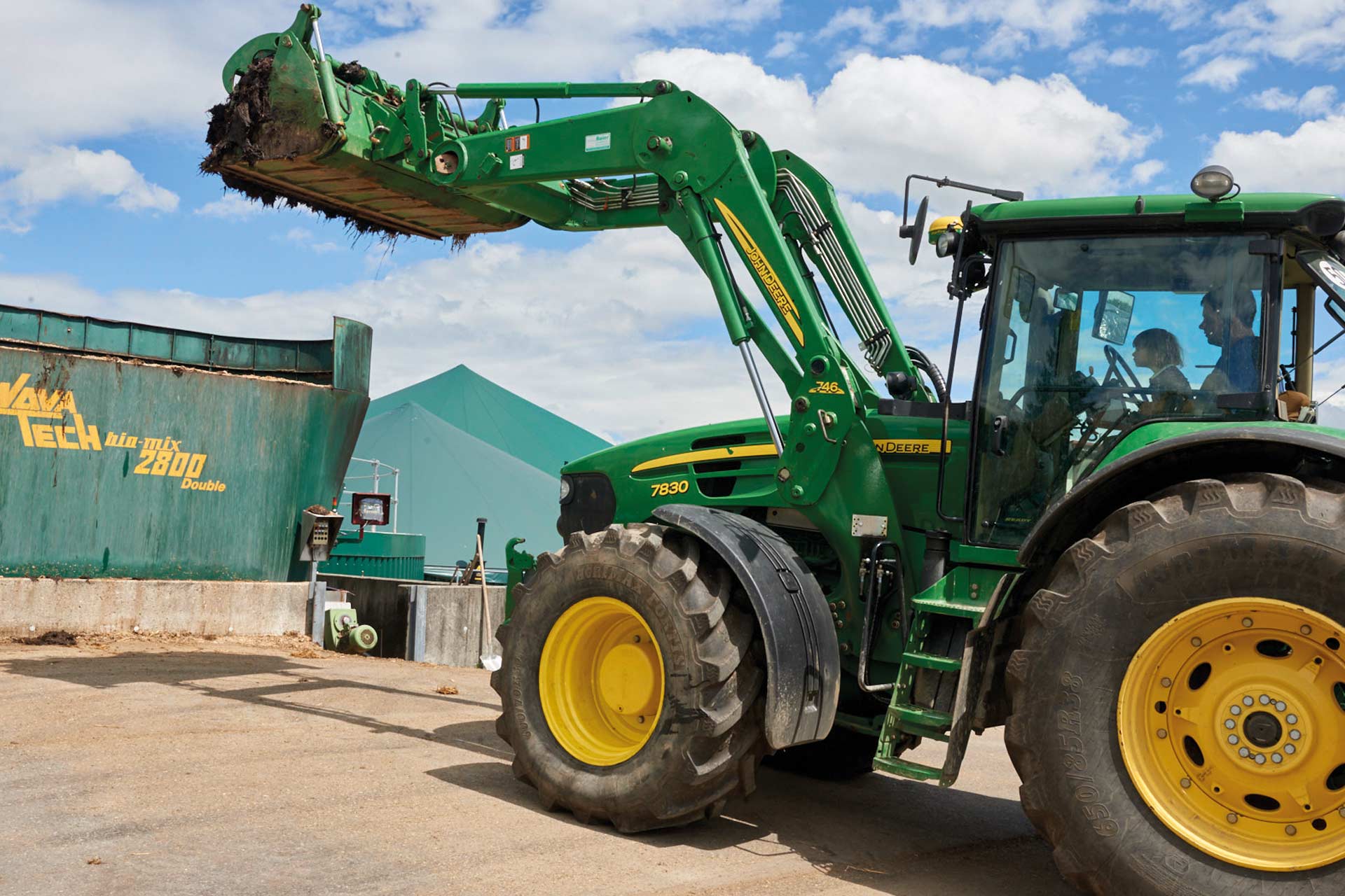 Der Landwirt fährt den Mist mit dem Traktor in die Biogasanlage