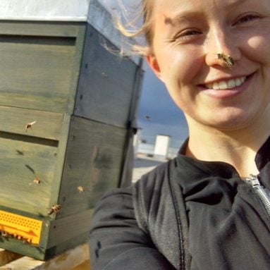 Katharina Schmidt direkt neben einem Bienenstock