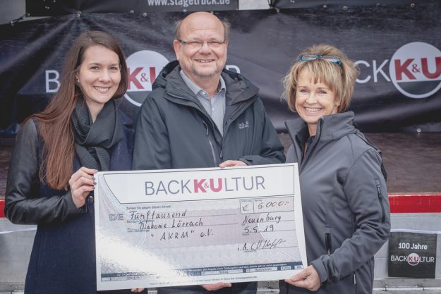 Mitarbeiterin der Bäckerei K&U übergibt Spendenscheck an Jörg Breiholz und Daniela Schmidle von der Diakonie Lörrach.